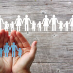 Rubrica Salute e Benessere: Mettere confini, La difficile arte di tutelare se stessi Paper family in hands on wooden background with white families